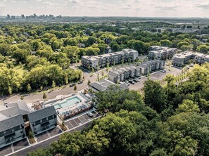 A residential area with apartment buildings, a swimming pool, and surrounding greenery. - Landing | Beautiful 1BD, Clubhouse, Pool (Nashville)