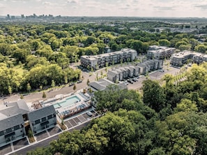 A residential area with apartment buildings, a swimming pool, and surrounding greenery. - Landing | Spectacular 2BD, Pool, Gym (Nashville)