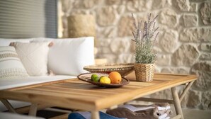 Une table basse en bois sur laquelle repose un panier tressé contenant des fruits et une plante en pot.