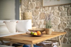 A wooden coffee table with a woven basket containing fruits and a potted plant. - Villa Lyra by Villas Hvar (Ivan Dolac)