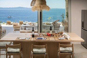 A dining area with a table set for four, overlooking a scenic ocean view. - Villa Lyra by Villas Hvar (Ivan Dolac)