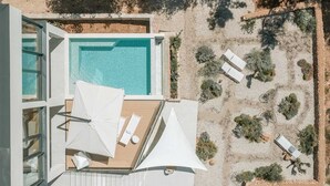 An aerial view of a rooftop pool area with a clear blue pool, white umbrellas, and lounge chairs. - Villa Gelos by Villas Hvar (Zavala)