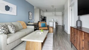 En moderne stue med sofa, sofabord og fjernsyn.
