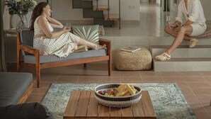 A modern living room with a staircase, a sofa, a coffee table with a basket, and a hat on the floor. - Villa Lesina by Villas Hvar (Vrboska)