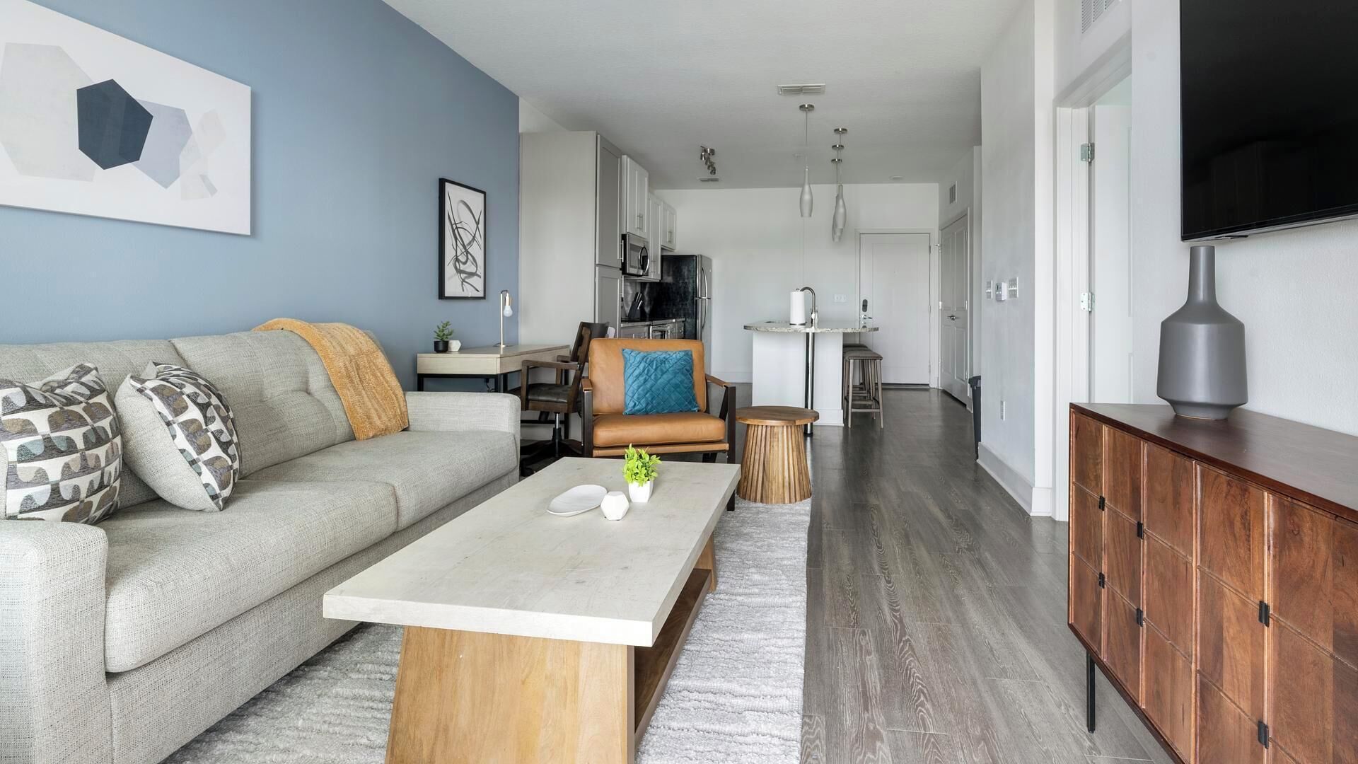 A modern living room with a sofa, coffee table, and a TV.
