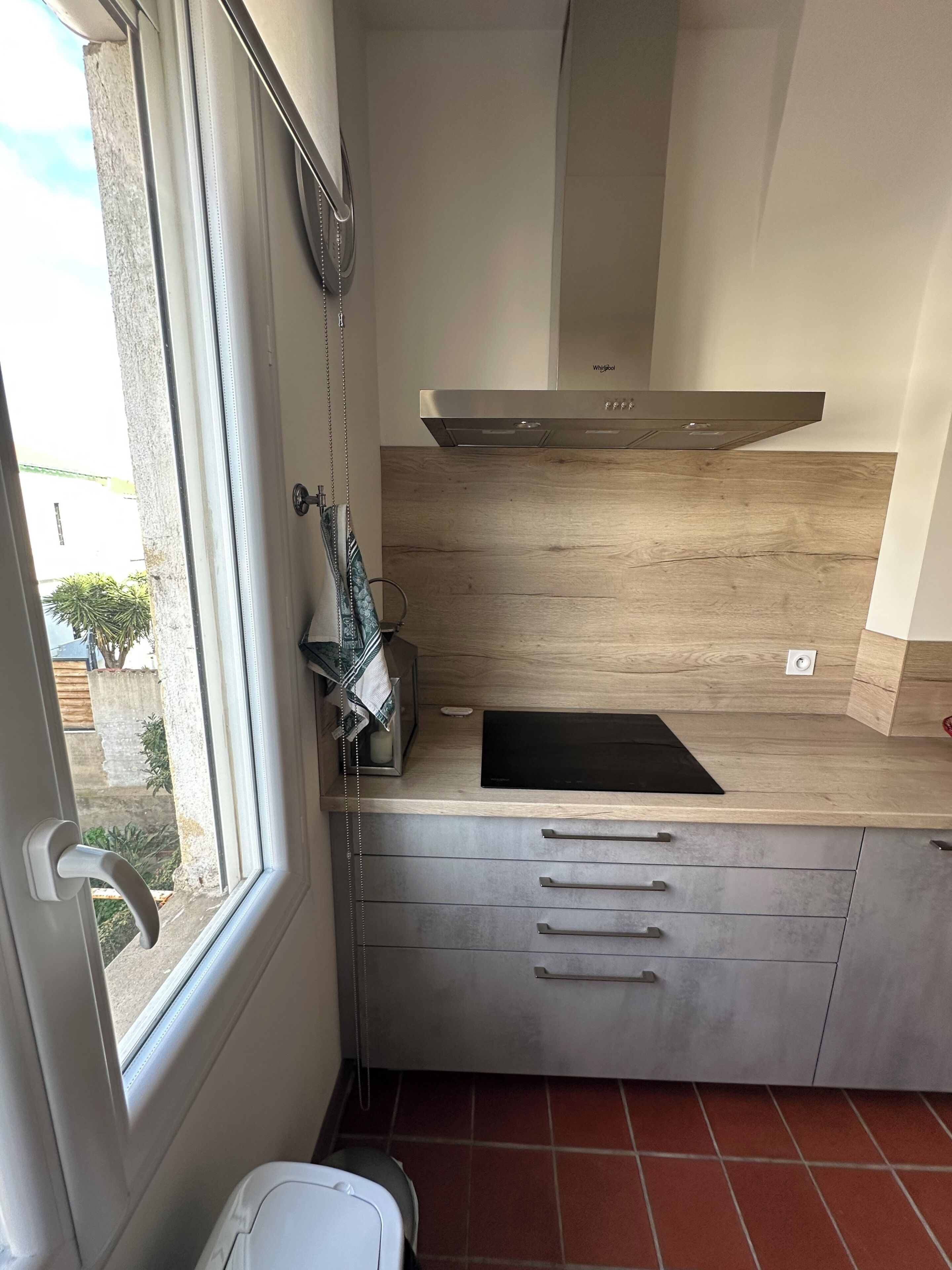 A compact kitchen with a window, a built-in stove, and a countertop.