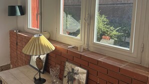A room with a table, lamp, and framed artwork. - Apartment Perpignan center 92 m2, 2 bedrooms 2 bathrooms, parking (Perpignan)