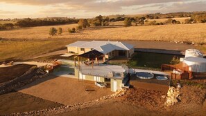 A large house with a patio, a swimming pool, and a large water tank.