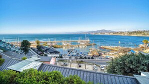 Marina costera con barcos, cielo despejado y edificios en primer plano.