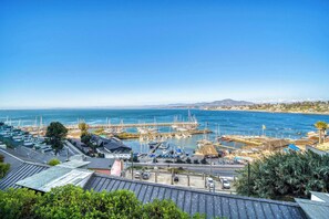 Marina costera con barcos, cielo despejado y edificios en primer plano.