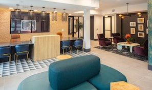 A modern hotel lobby with a bar area, seating, and artwork on the walls. - Landing | Amazing 1BD, Pool, Clubhouse (Austin)