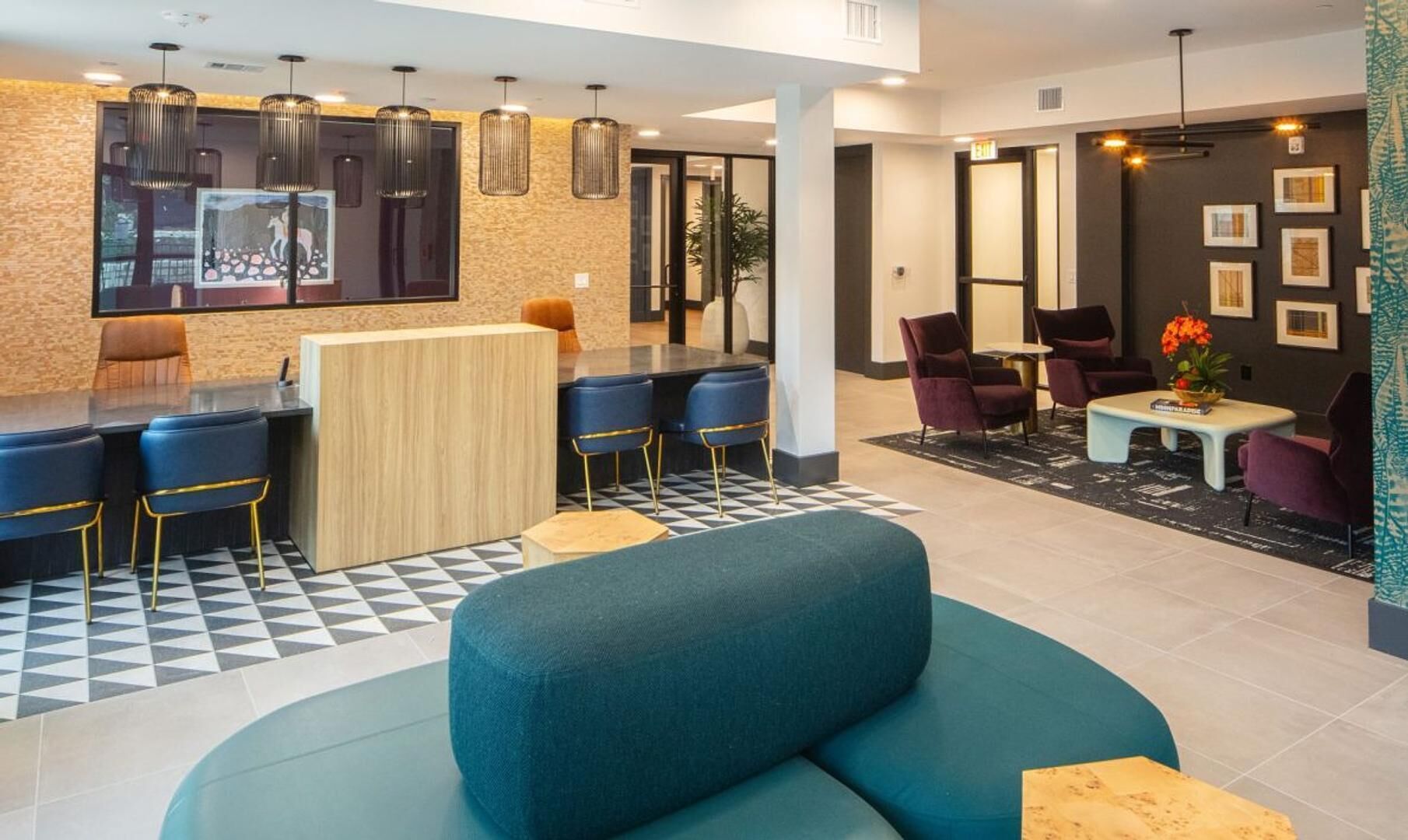 Eine moderne Hotelhalle mit Barbereich, Sitzgelegenheiten und Kunstwerken an den Wänden.
