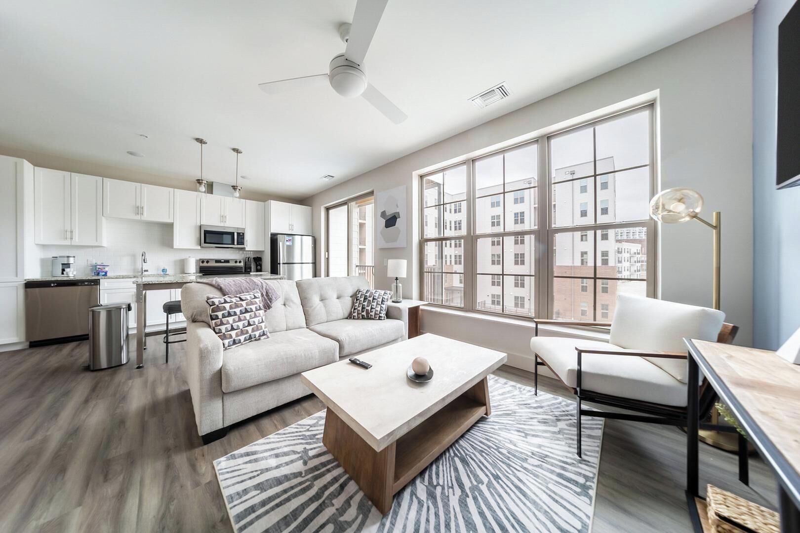 A modern apartment with a kitchen, living area, and large windows.