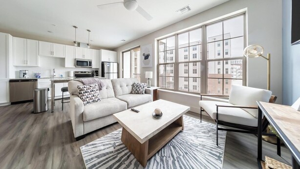 A modern apartment with a kitchen, living area, and large windows. - Landing | Modern 1BD, Gym, Clubhouse (Cleveland)
