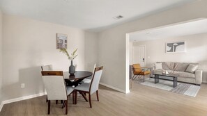 A modern living room with a dining area, a sofa, and a coffee table.