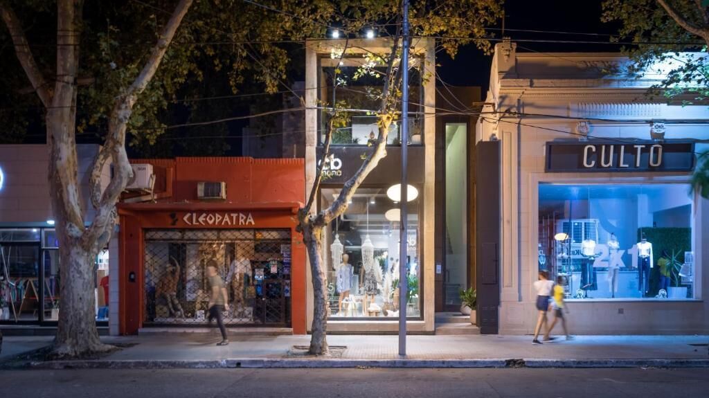 A street view at night with a storefront named 'CLEOPATRA' and another named 'CULTO.'