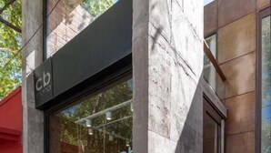 A storefront with a large glass window, a visible entrance, and a partial view of the interior. - CB Mona Suites (Villa Mercedes)