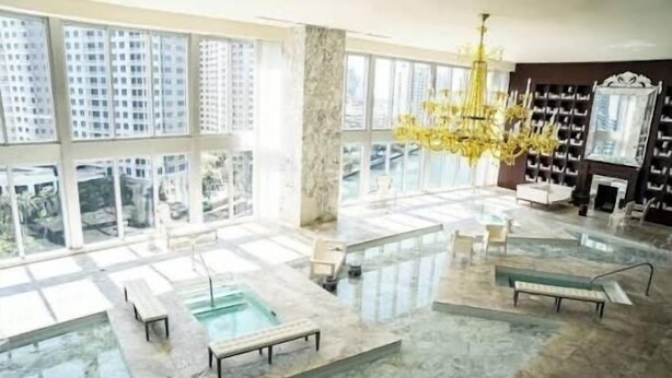 A spacious indoor pool area with multiple seating areas and a large chandelier. - LUXORA 2BR 1 BA 16TH FLOOR W -FREE SPA (Miami)