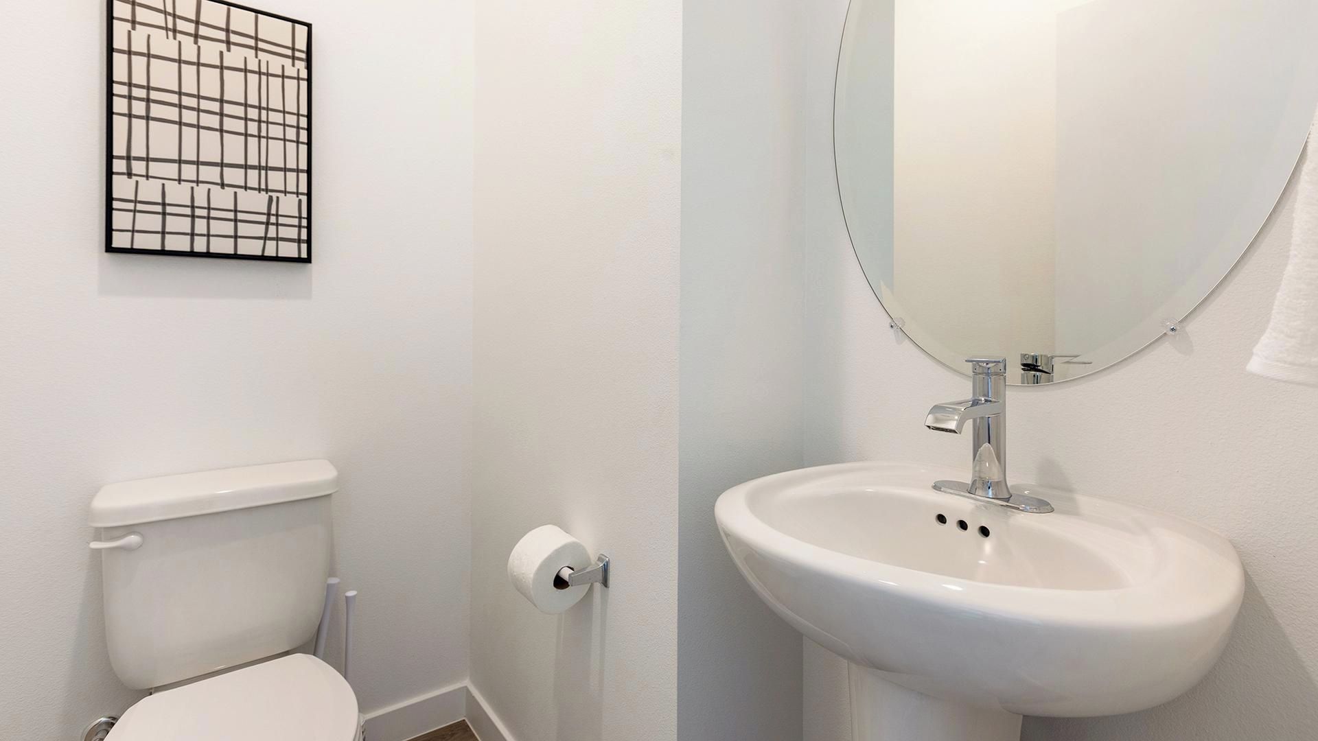 Ein Badezimmer mit Toilette, Waschbecken und Spiegel.
