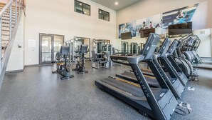 Una palestra con tapis roulant, macchinari per pesi e un grande murale.