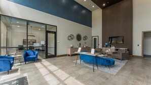 Un'ampia hall con reception, area relax e un grande schermo televisivo.