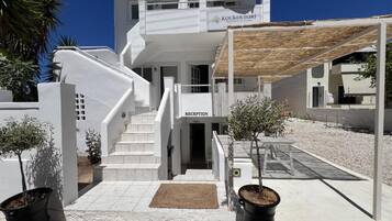 Un edificio moderno con una recepción, una escalera y plantas en macetas.