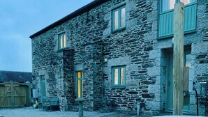 A stone building with a hot tub in front. - Stunning Coastal Barn With hot tub (Falmouth)
