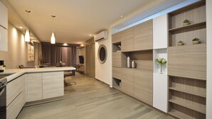Une cuisine moderne dotée d’un îlot central, de luminaires suspendus, de meubles de rangement intégrés et d’une fenêtre ronde.