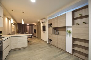 A modern kitchen with a central island, pendant lighting, built-in cabinetry, and a round window. - Semillero Obispado (Monterrey)
