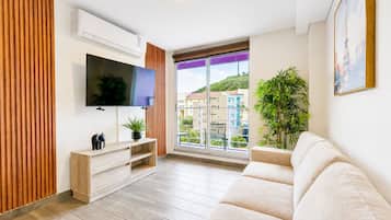 Suite empresarial, vista a la ciudad | Área de sala de estar | Smart TV de 60 pulgadas con canales digitales y servicios de streaming