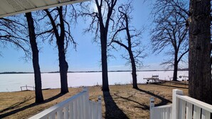 A wooden deck leading to a lake with trees and a picnic table. - Lakefront Escape - Breathtaking Views in Fox Lake (Fox Lake)