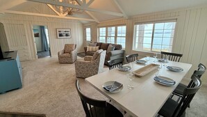A spacious dining area with a high ceiling and large windows overlooking a body of water. - Lakefront Escape - Breathtaking Views in Fox Lake (Fox Lake)