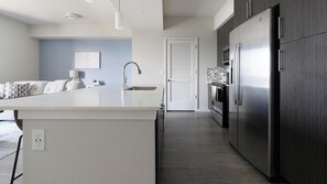 Eine moderne Küche mit Kochinsel, Edelstahlgeräten und minimalistischem Design.