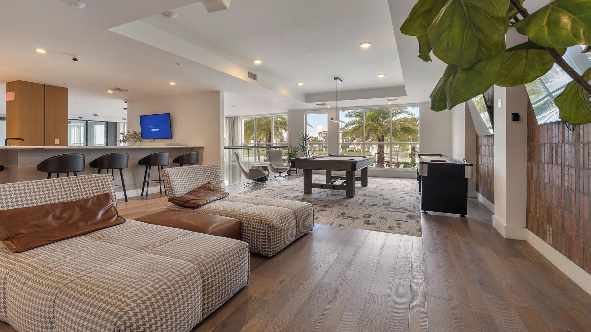 A spacious living area with a pool table, comfortable seating, and a view of the outdoors.
