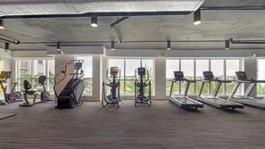 A gym with treadmills, elliptical machines, and a stair climber. - Landing | Modern 2BD, Clubhouse, Gym (Fort Myers)