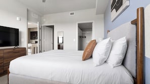 A hotel room with a bed, a television, a wardrobe, and a kitchenette. - Landing | Chic 2BD, Clubhouse, Gym (Fort Myers)