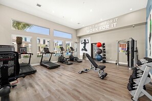 A gym with treadmills, elliptical machines, a bench press, and a squat rack. - Landing | Stunning 2BD, Gym (North Las Vegas)