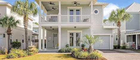 A two-story house with a balcony, a garage, and a well-maintained lawn.