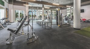 Ein Fitnessstudio mit diversen Trainingsgeräten, großen Fenstern und einem klaren, modernen Design.
