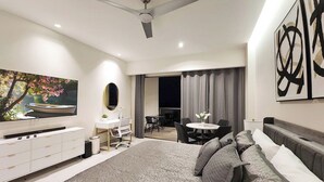A modern bedroom with a large bed, a desk, a dining table, and a TV. - Luxury, Family-Friendly Studio 1-0802A on the Beach! (Puerto Peñasco)