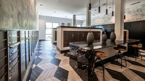 A modern kitchen with a marble island, pendant lighting, and a herringbone floor pattern. - Landing | Incredible 1BD, Clubhouse, Gym (Lewisville)