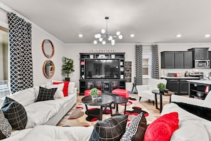 Ein modernes Wohnzimmer mit einer Couch, einem Couchtisch und einer TV-Konsole mit einem Flachbildfernseher.