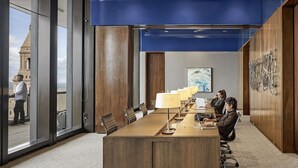 Une salle de conférence dotée d’une longue table, de chaises et offrant une vue sur l’extérieur grâce à de grandes fenêtres.