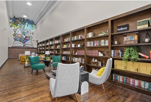 Eine Bibliothek mit Bücherregalen, einer Wandmalerei und Sitzbereichen.