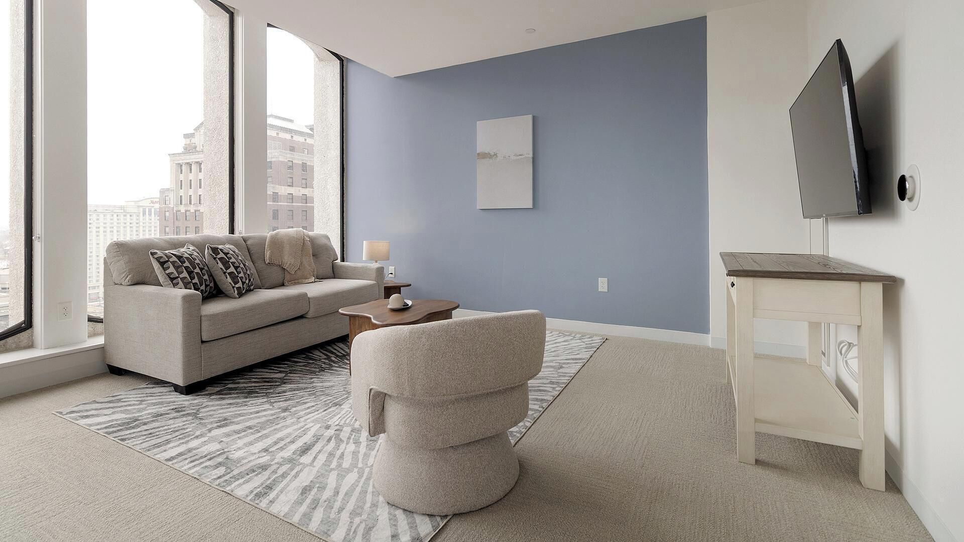Een moderne woonkamer met een bank, salontafel en een televisie op een dressoir.