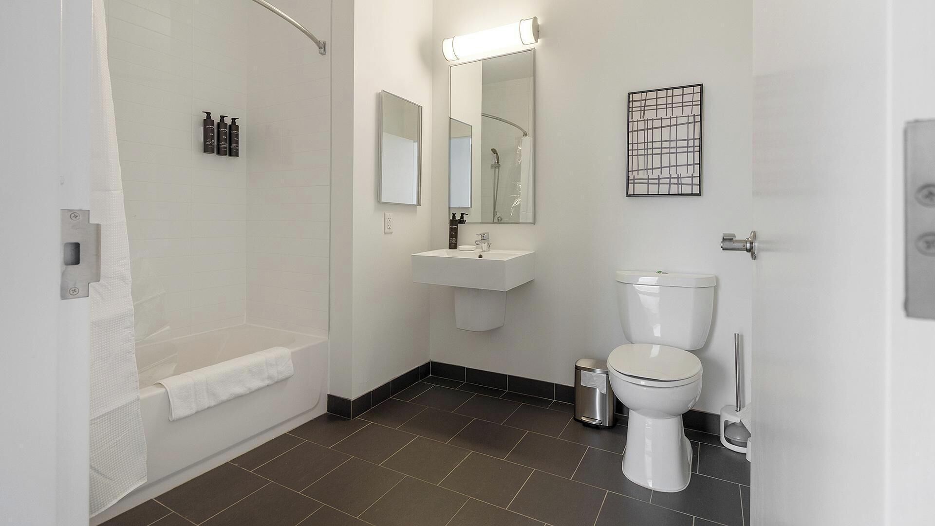 A modern bathroom with a shower, toilet, and sink.