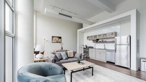 Een moderne woonkamer met een bank, salontafel en een eethoek.
