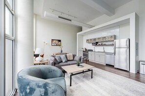Ein modernes Wohnzimmer mit Sofa, Couchtisch und Essbereich.