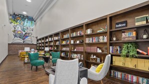 Een bibliotheek met boekenkasten, een muurschildering en zitgedeeltes.