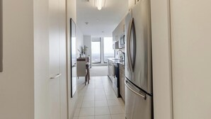Una cucina moderna con elettrodomestici in acciaio inossidabile, vista dalla finestra e un design pulito e minimalista.